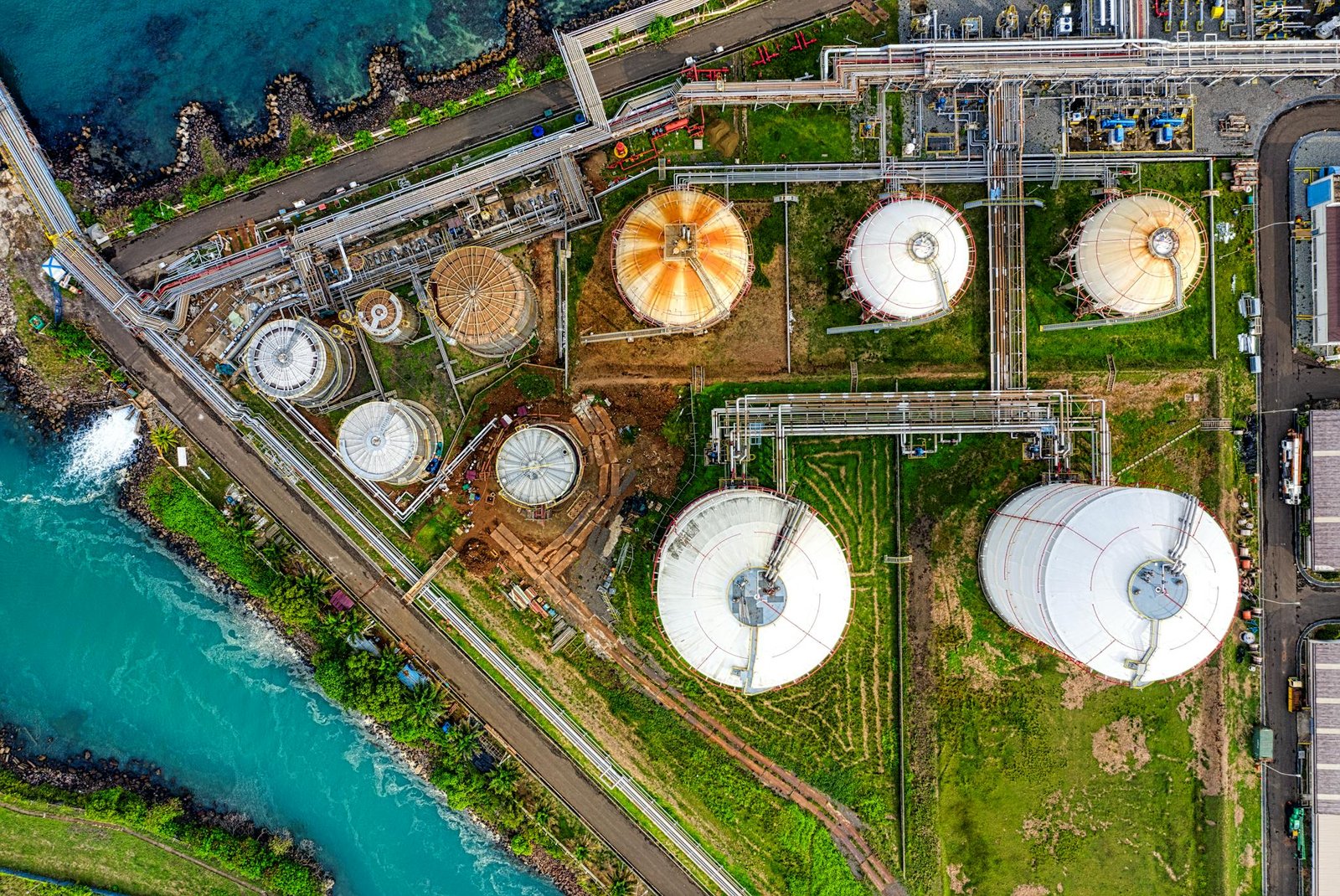Aerial view of an industrial complex near a river in Banten, Indonesia, showcasing storage tanks.